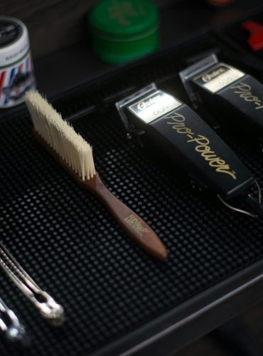 Close-up of hair clippers and grooming tools in a modern barbershop setup.